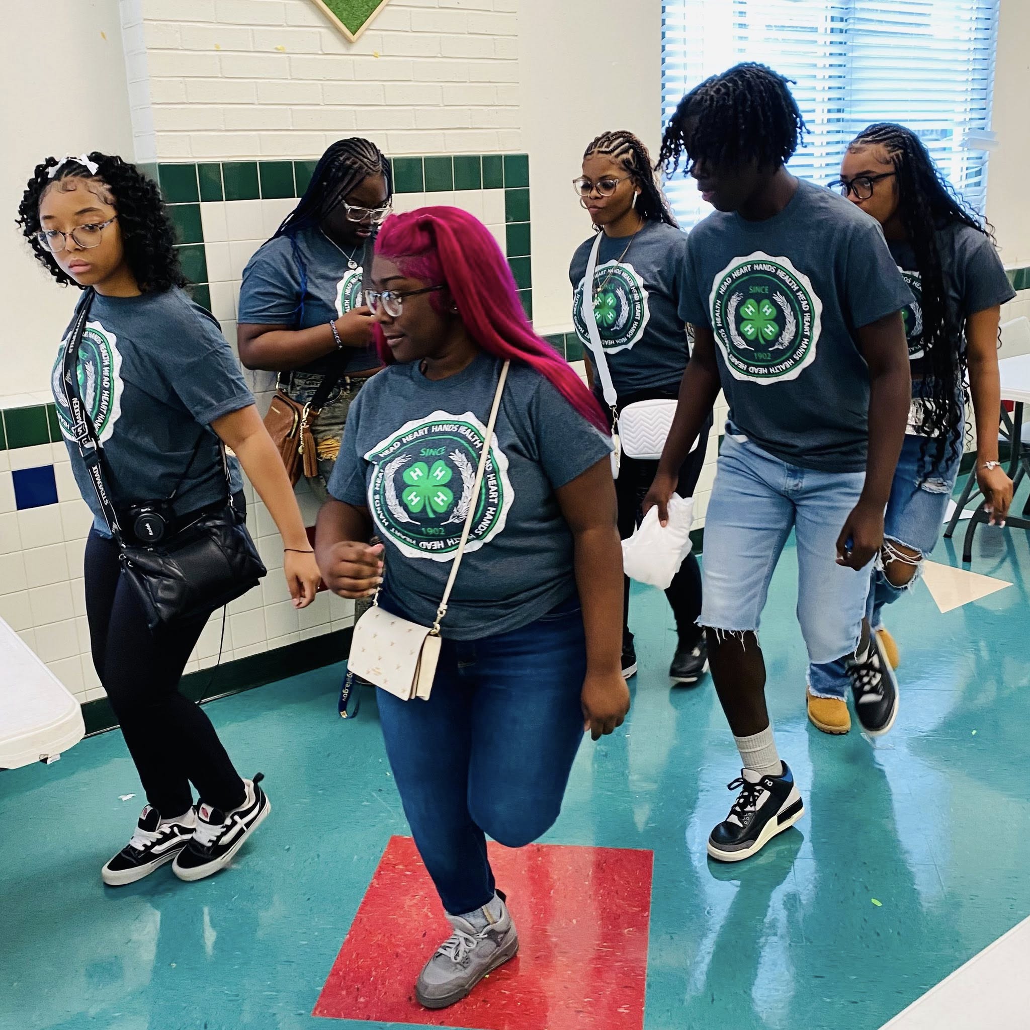 A group of teenagers line dancing.